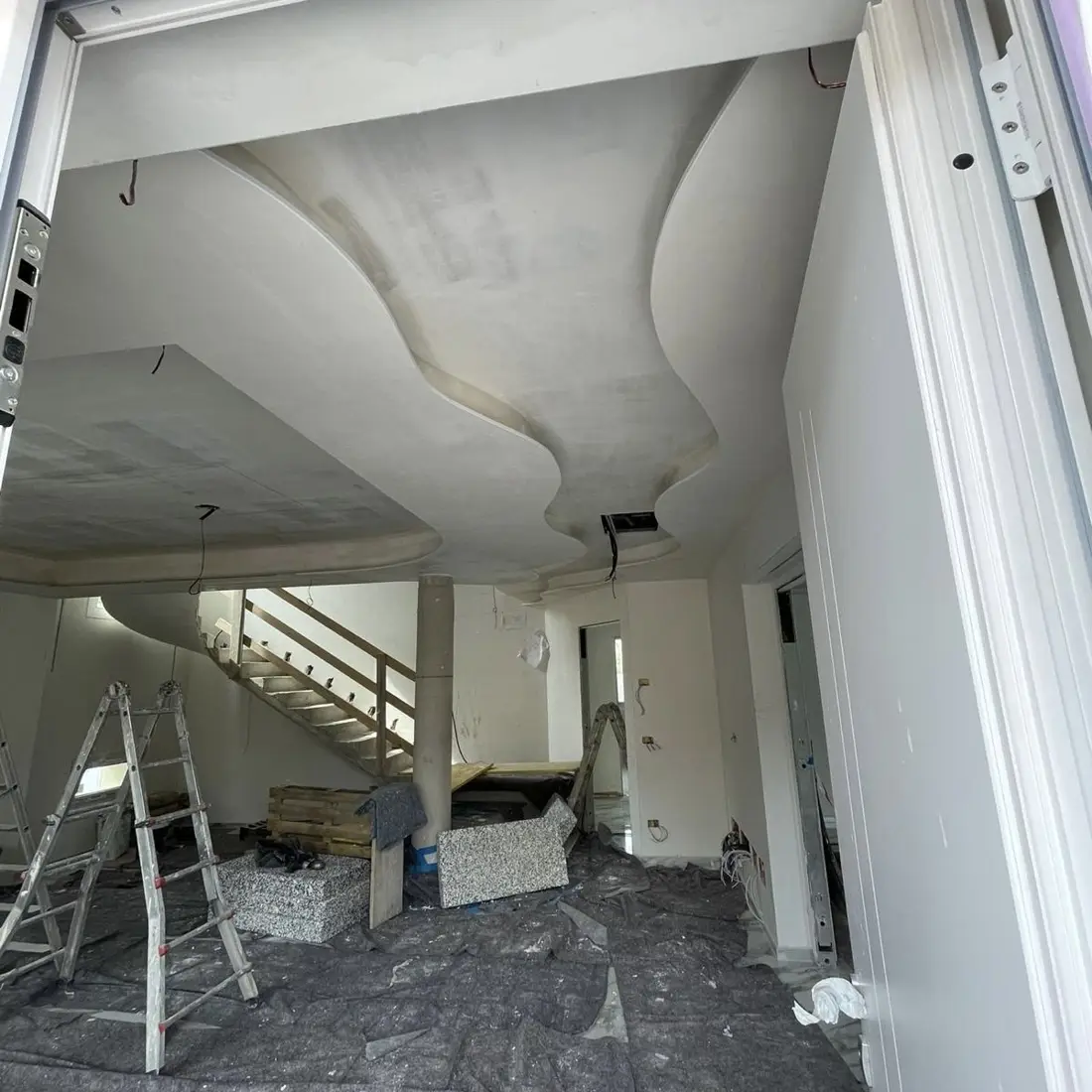 Controsoffitto in cartongesso sagomato, ingresso di un'abitazione in cantiere